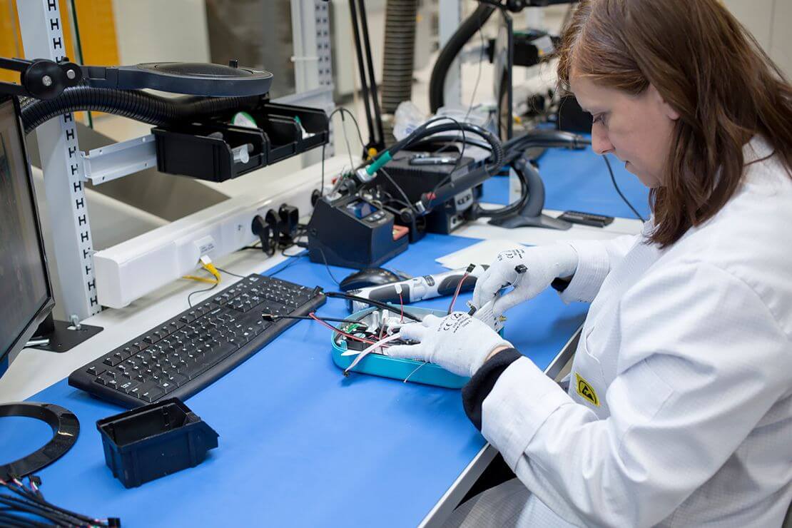 Kobieta w białym kitlu buduje robota w laboratorium