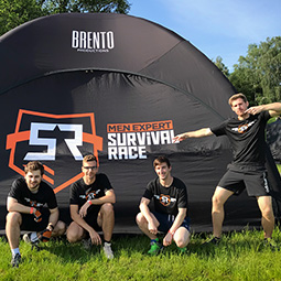 Czterech mężczyzn w sportowych strojach bierze udział w Survival Race