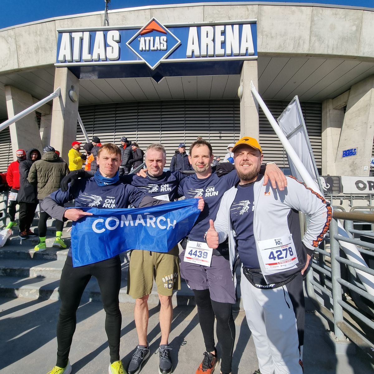 Comarchowi biegacze pozujący do zdjęcia pod Atlas Areną w Łodzi