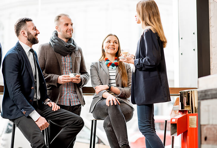 Grupa ludzi rozmawia ze sobą podczas przerwy na kawę w ramach networkingu