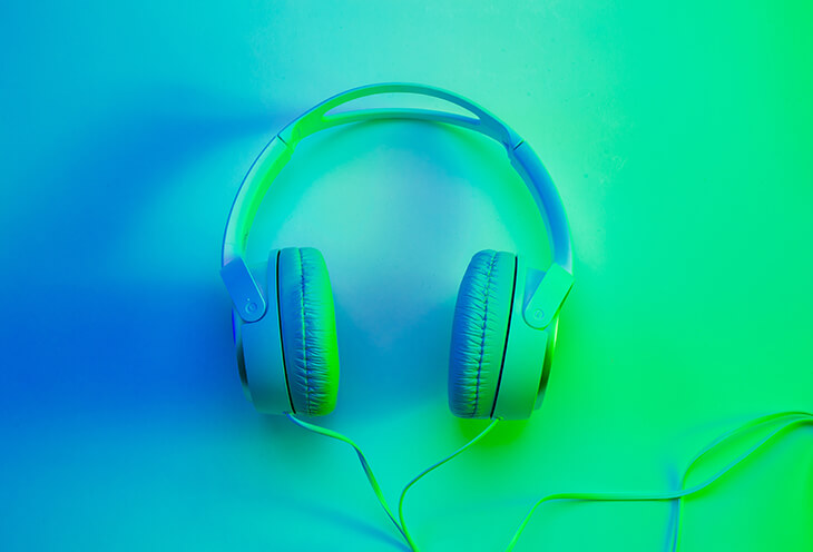 Zielone słuchawki nauszne na niebieskim tle 