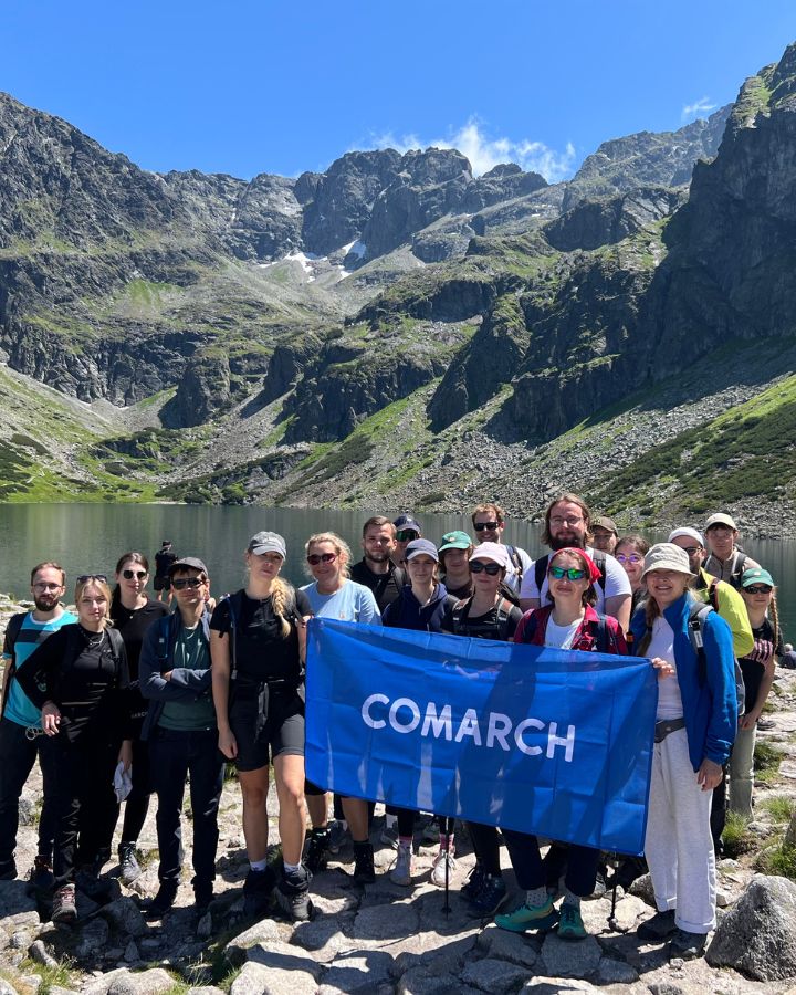 Grupa pracowników pozująca do zdjęcia na tle Morskiego Oka