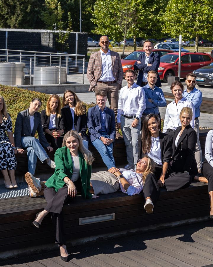 Zgrany zespół pozuje do zdjęcia na terenie kampusu Comarch