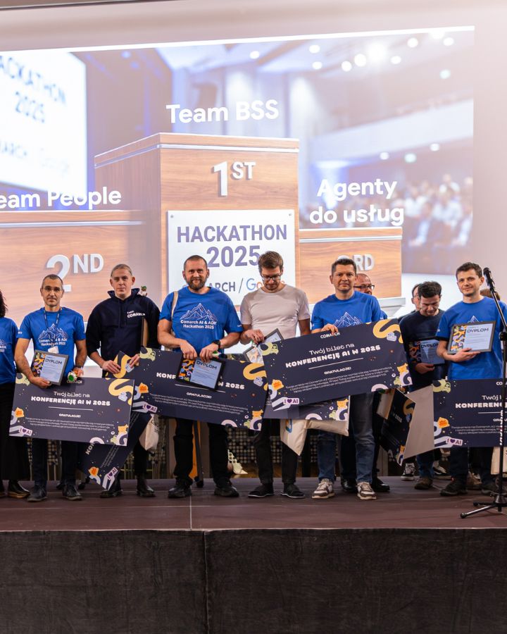 Finał Comarch AI Hackathonu, zwycięzcy pozują do zdjęcia z zaproszeniami na konferencję AI