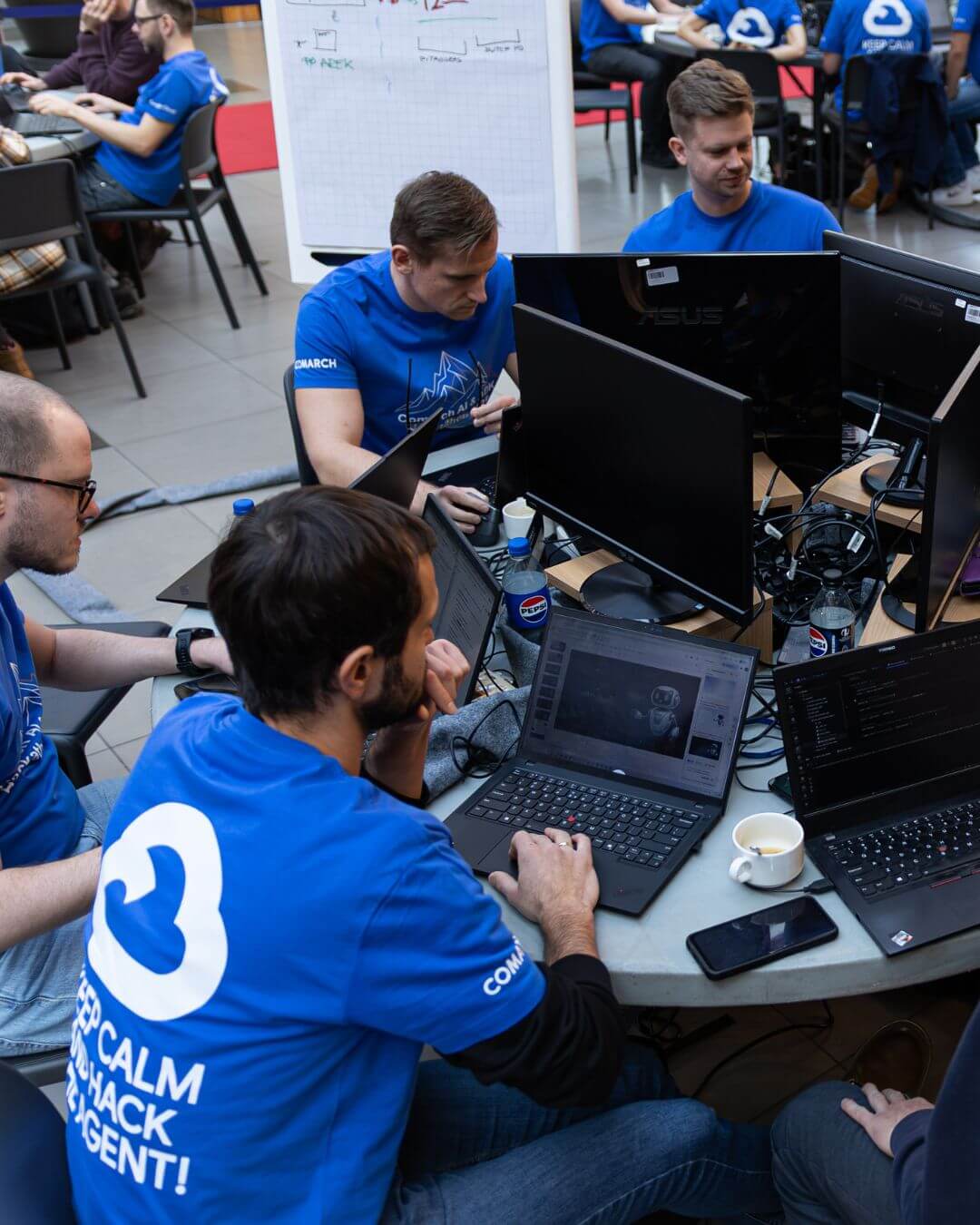Inżynierowie uczestniczący w Comarch AI Hackathon podczas pracy zespołowej przy kompterach