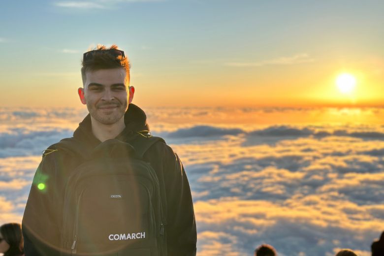 Pracownik Comarch podczas górskiej wyprawy "nad chmurami" w bluzie z logo Comarch