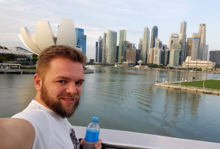 Młody mężczyzna robi zdjęcie podczas wycieczki w Singapurze